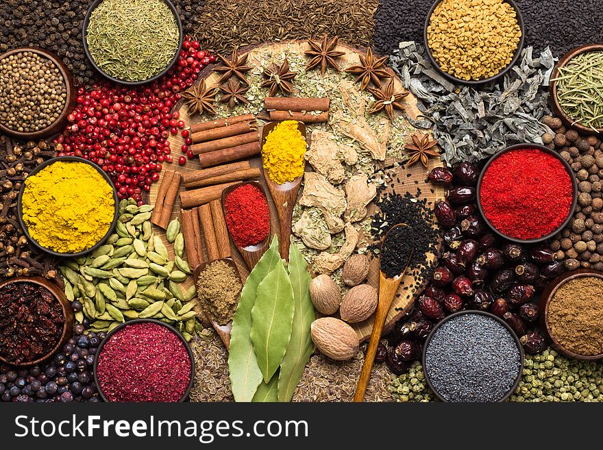 Colorful spices and herbs background. Large set seasonings scattered on table. Colorful spices and herbs background. Large set seasonings scattered on table