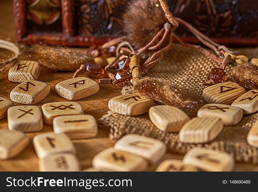 Handmade scandinavian wooden runes on a wooden vintage background. Concept of fortune telling and prediction of the