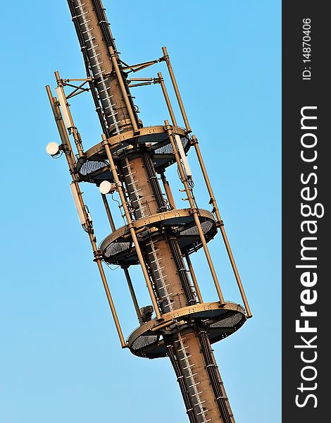 Telecommunication monopole tower section with antennas over blue sky. Telecommunication monopole tower section with antennas over blue sky.