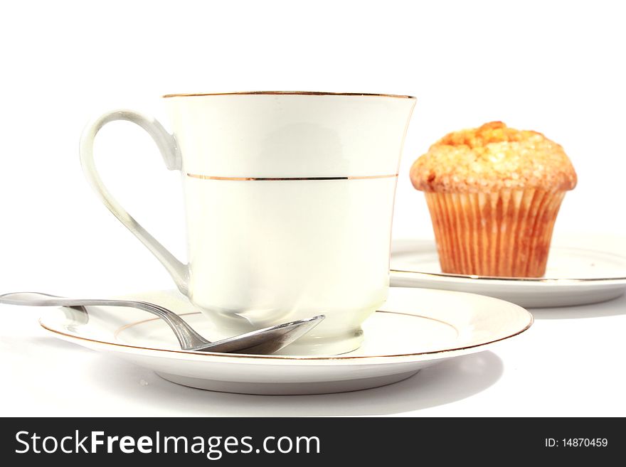 White cup and saucer with muffin. White cup and saucer with muffin