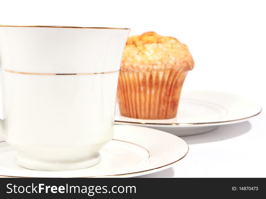 White cup with saucer and muffin. White cup with saucer and muffin