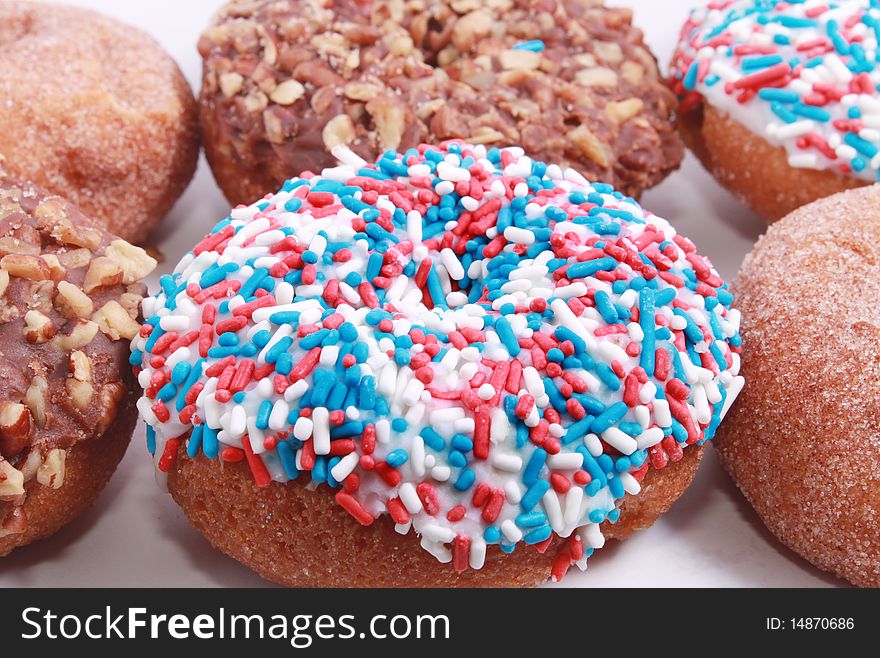Many donuts with white, blue and red sprinkles