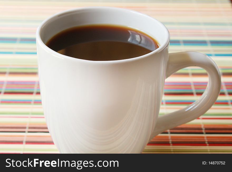 Coffee cup on colorful placemat