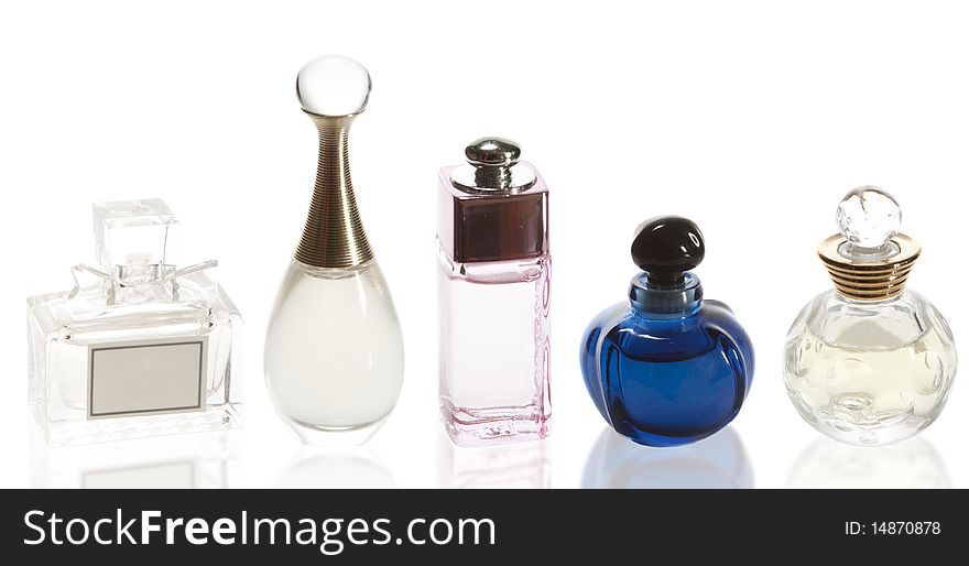 Five different perfumes on a white background with reflection