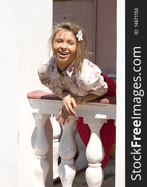 Laughing girl standing on a veranda