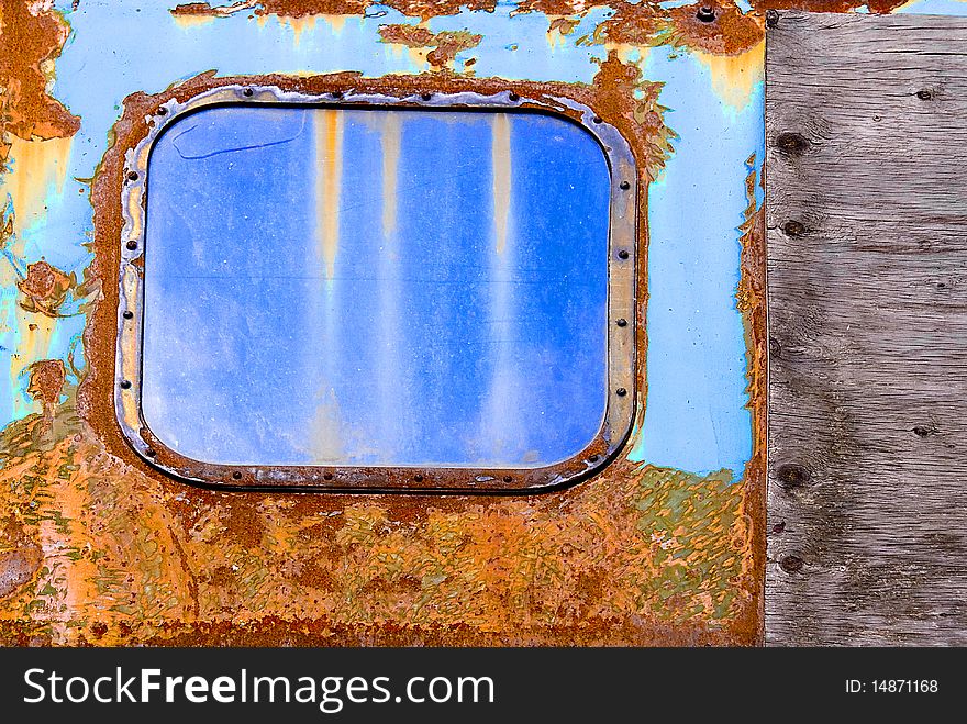 Colorful rust structures and a small window of an old steam engine. Colorful rust structures and a small window of an old steam engine