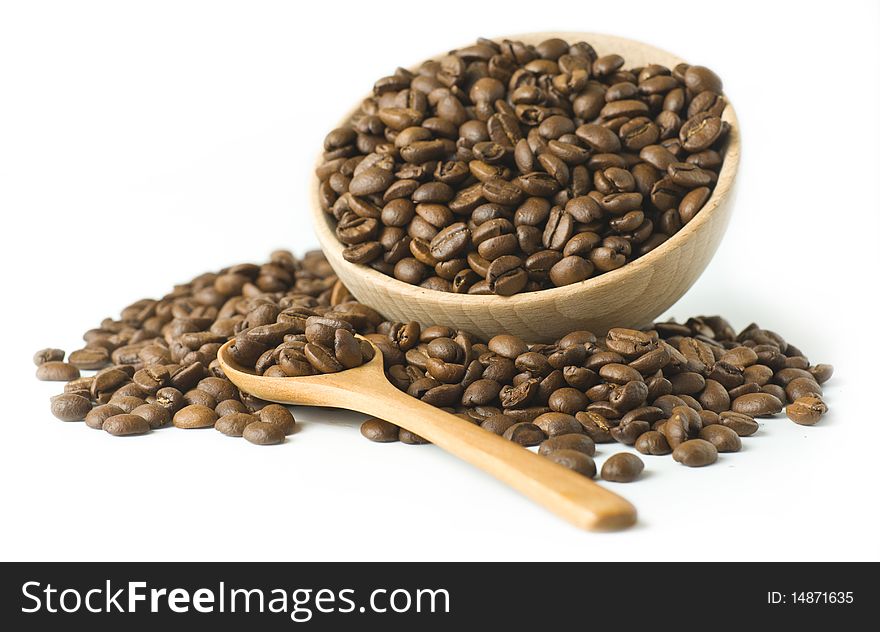 Wooden cup full with coffee beans with a wooden spoon. Wooden cup full with coffee beans with a wooden spoon