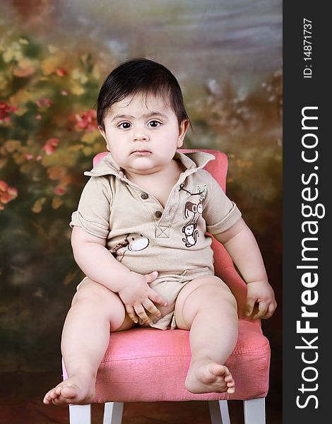 A cute chubby baby sitting on a chair. A cute chubby baby sitting on a chair.