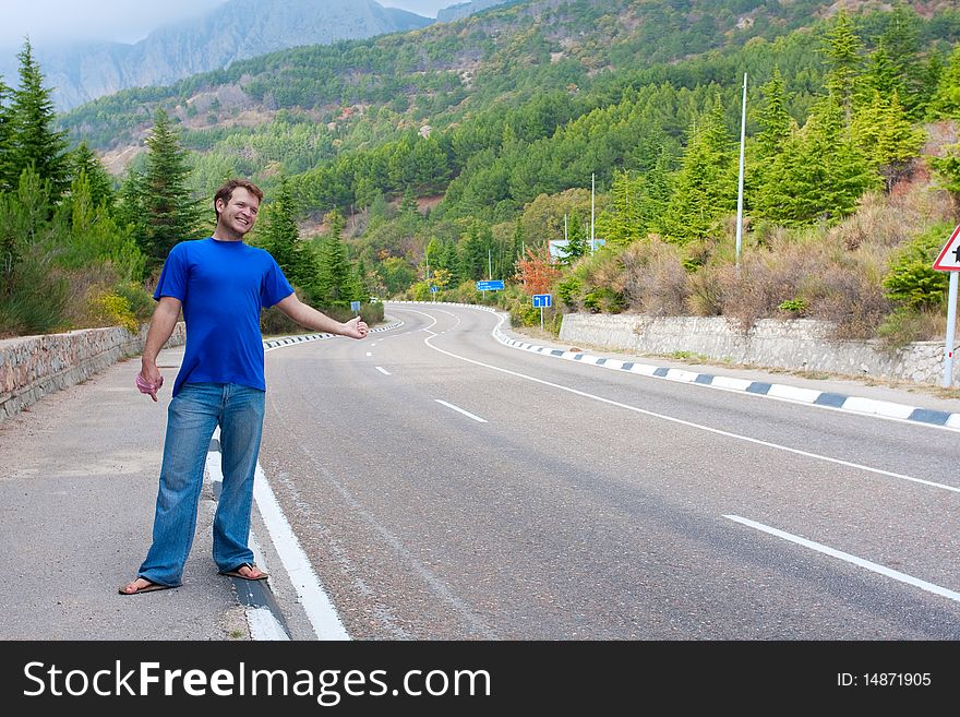 Man Hitchhiking On A Country Road