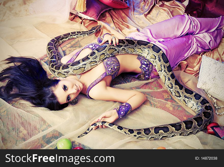 Shot of an oriental woman posing with a python. Shot of an oriental woman posing with a python.