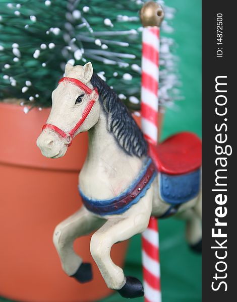 Merry-go-round horse christmas decoration against a miniature tree