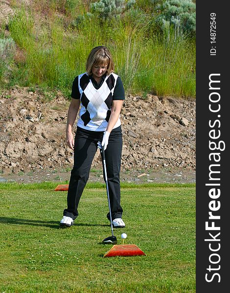 Blond female golfer on the tee-box with a driver