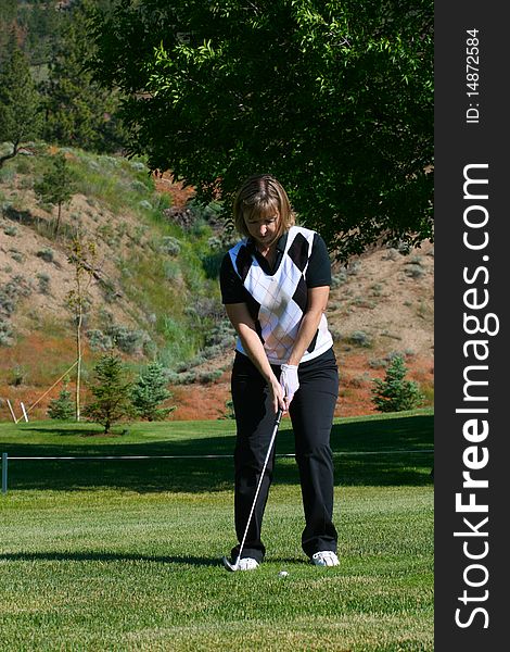 Female golfer preparing to play her shot