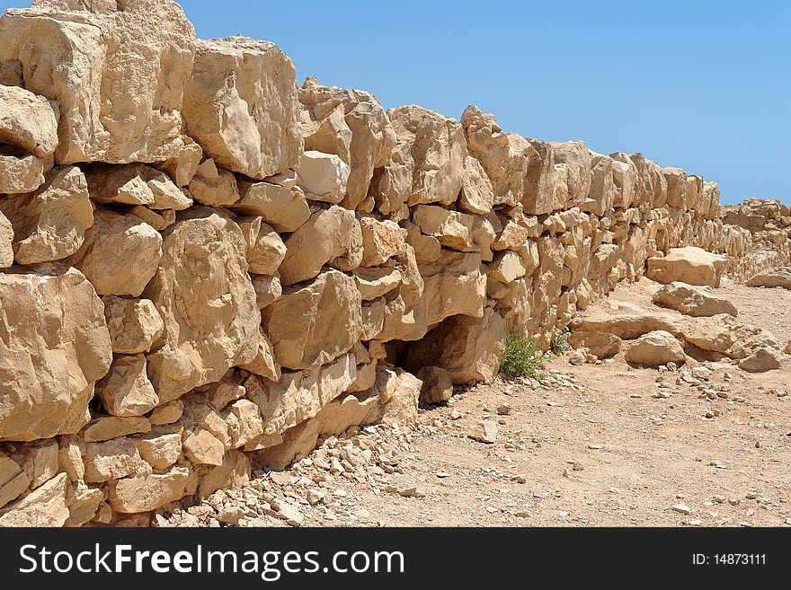 Broken wall of ancient fortress ruin converging in perspective