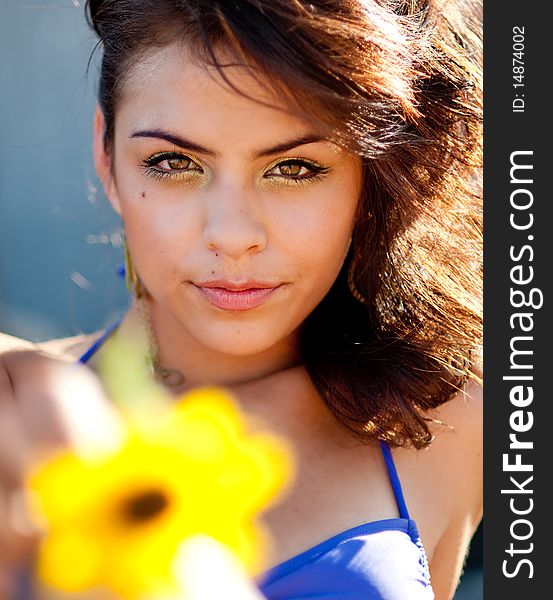 Portrait of a pretty young woman holding a sunflower