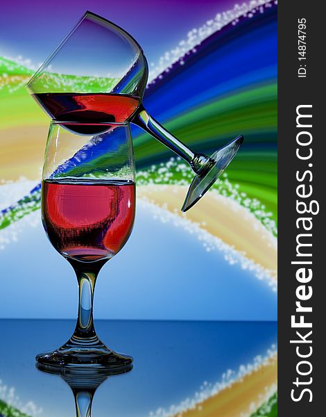Two glasses of red wine on colorful swirl background. Two glasses of red wine on colorful swirl background