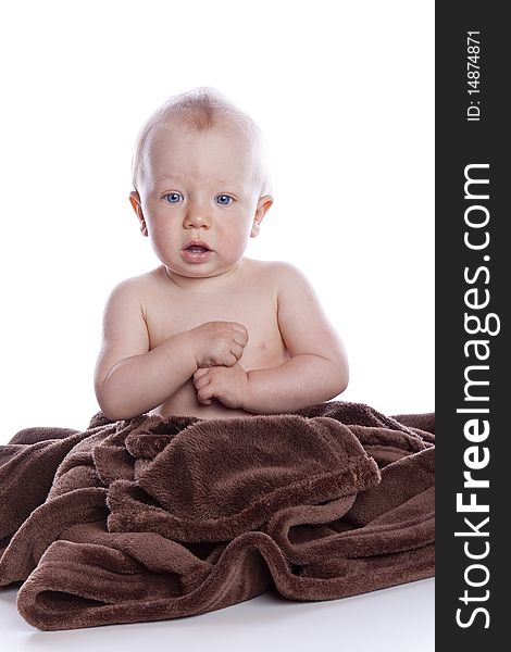 Beautiful baby under a brown towel on white background