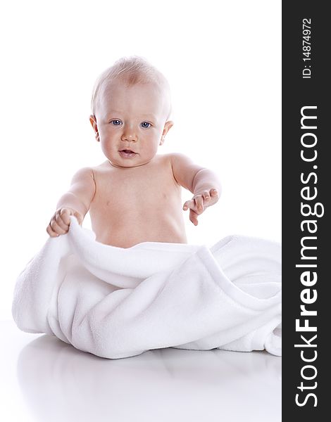 Beautiful baby under a white towel on white background