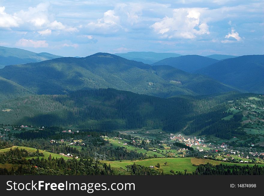 Panorama of Carpathian village with mountains and sky