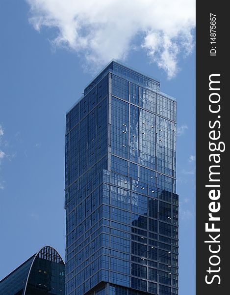 Reflection of a cloudy sky in glass wall of an office building