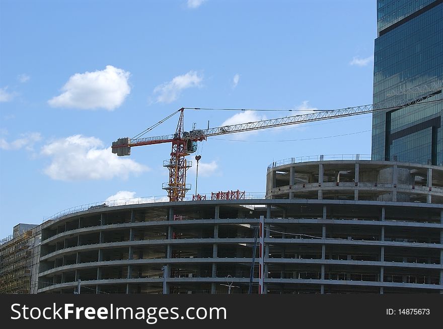 Construction crane at the windows of a skyscraper