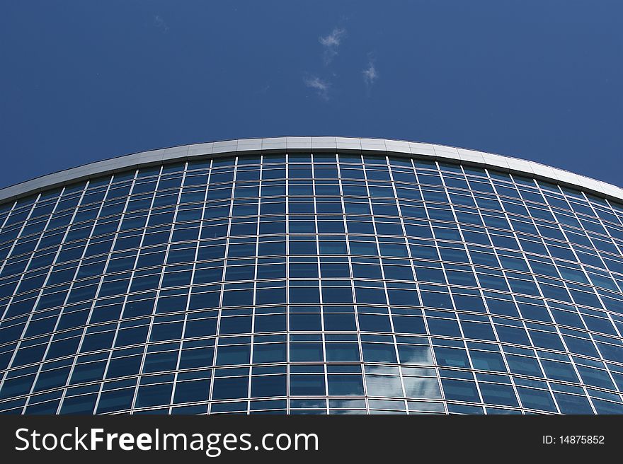 Reflection of a cloudy sky in glass wall of an office building