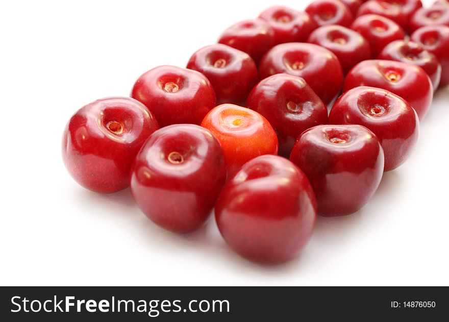 Isolated row of cherries one of them orange