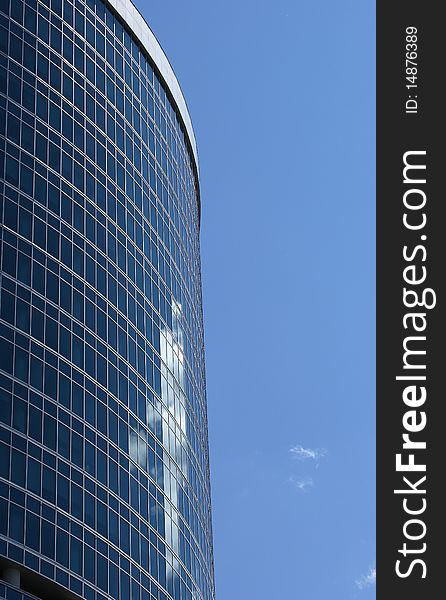 Reflection of a cloudy sky in glass wall of an office building