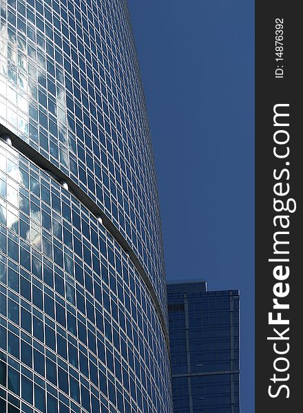 Reflection of a cloudy sky in glass wall of an office building