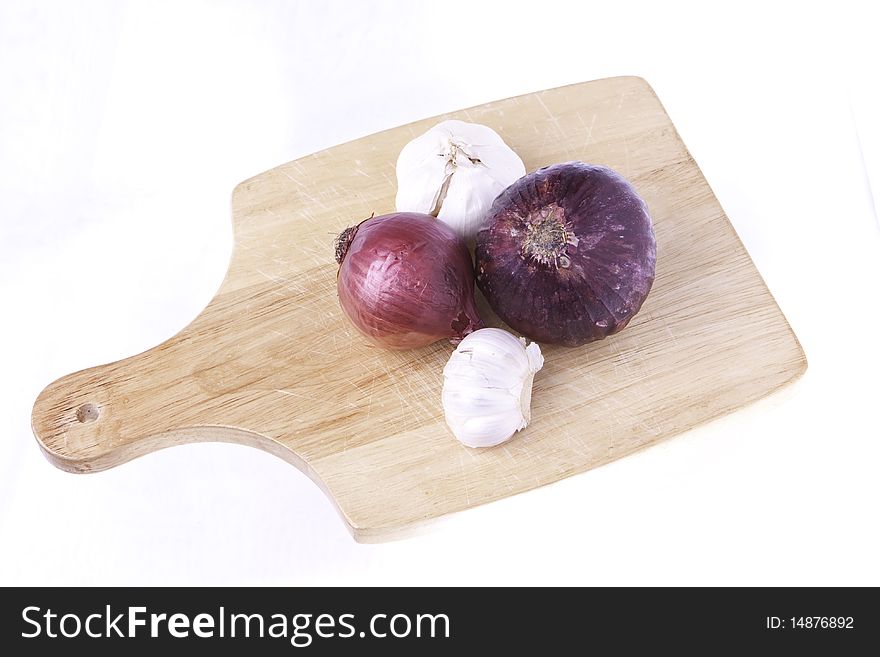 A selection of vegetables of root foods on a cutting board ready for cutting isolated on a white background. A selection of vegetables of root foods on a cutting board ready for cutting isolated on a white background