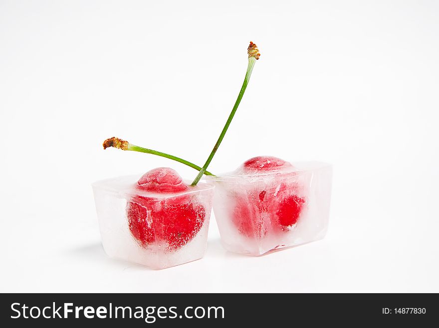 Two frozen cherries on white background