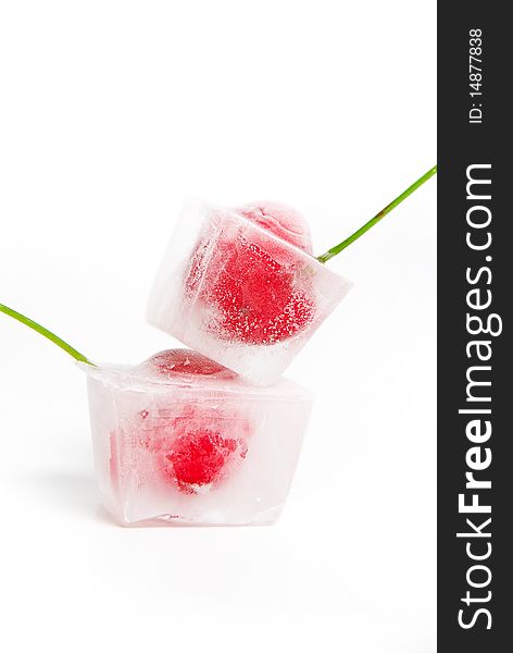 Two frozen cherries on white background.