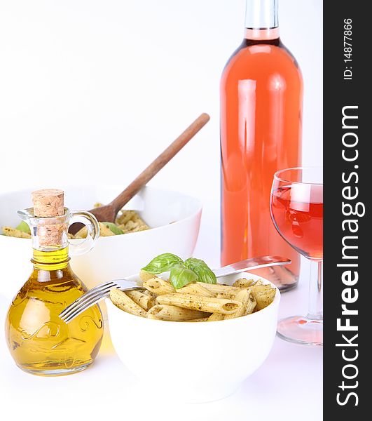 Penne with pesto, bottle of olive oil and pink wine. Penne with pesto, bottle of olive oil and pink wine