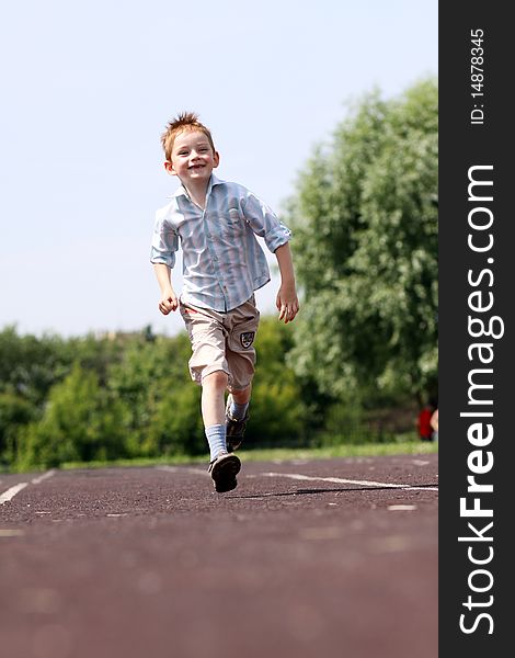 Little boy runs in a summer park