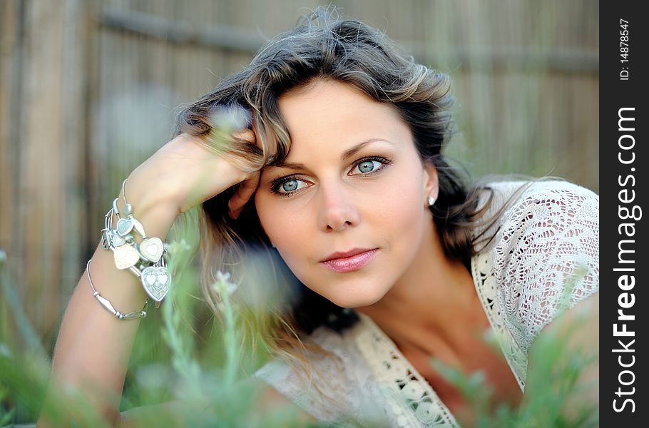 Young pretty summer woman lying on the grass outdoors. Young pretty summer woman lying on the grass outdoors