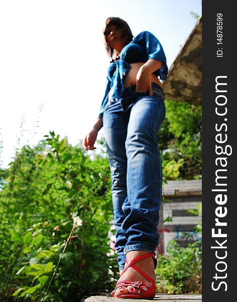 The young woman against the nature. Red barefoot persons. Jeans