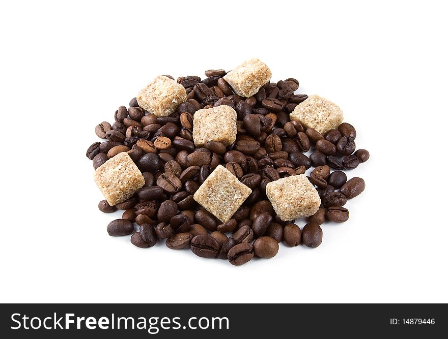 A heap of coffee beans with seven pieces of brown sugar isolated on white. A heap of coffee beans with seven pieces of brown sugar isolated on white