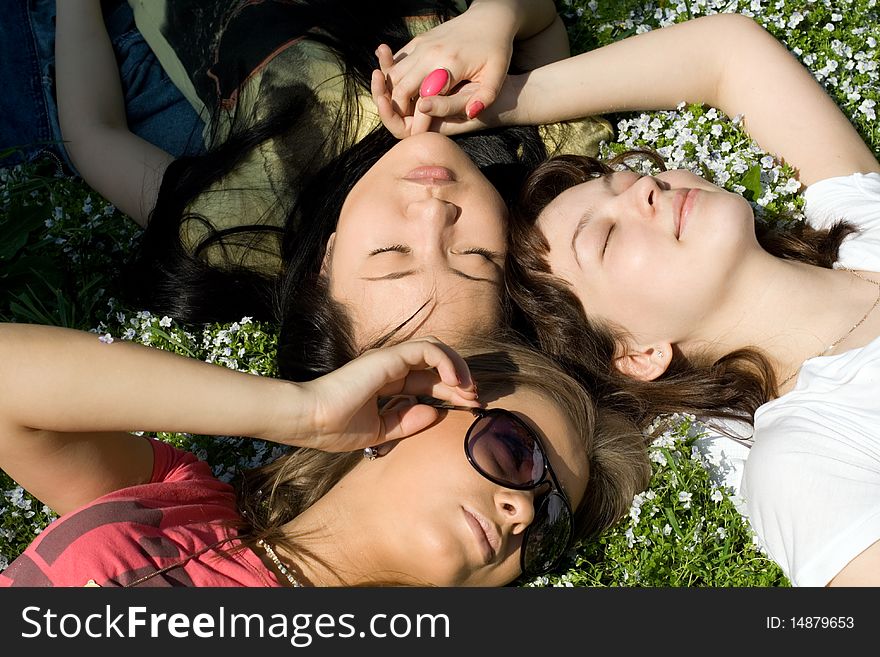 Three girls lying on grass