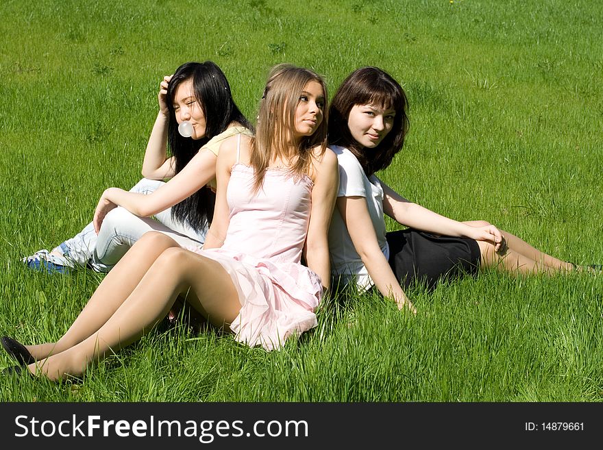 Three girls sitting on grass