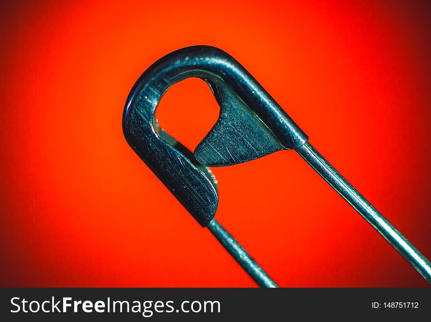 Maetal Safety Pin macro photo on red background