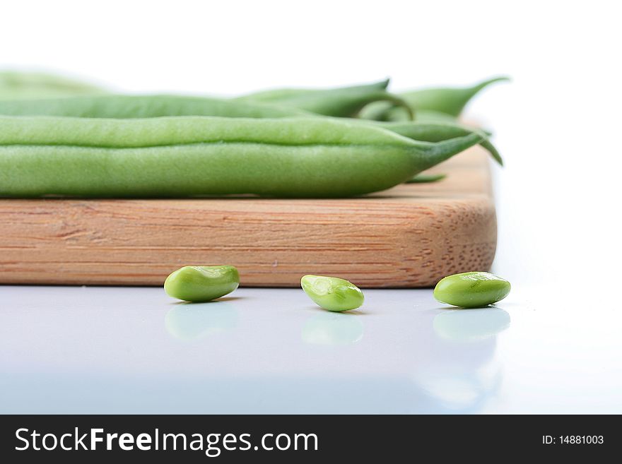 Vegetable kidney bean beans against on a kitchen board.