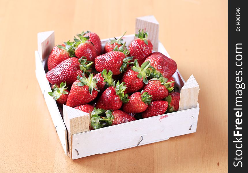 Fresh strawberries in a wooden crate - closeup