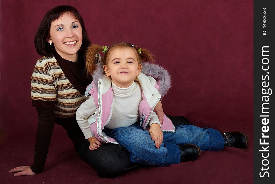 Happy mother with little daughter on red background