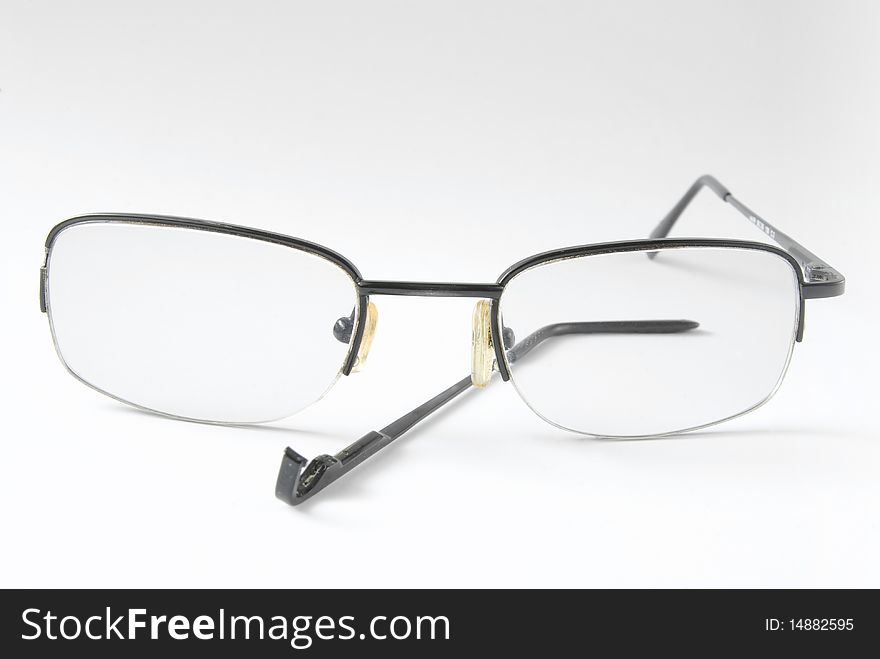 Broken eyeglasses over white background