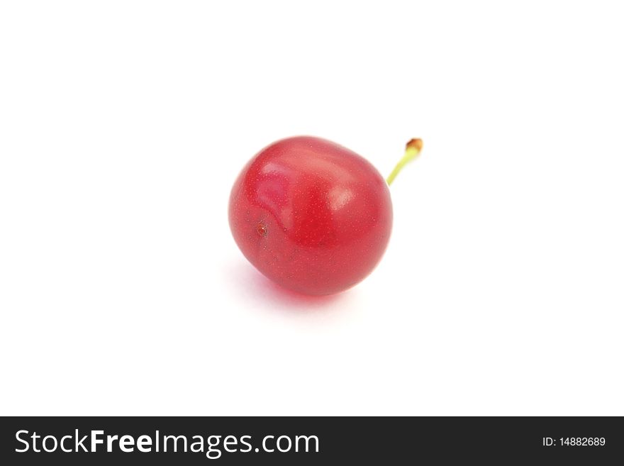 A single ripe cherry with a stem isolated on white background. A single ripe cherry with a stem isolated on white background