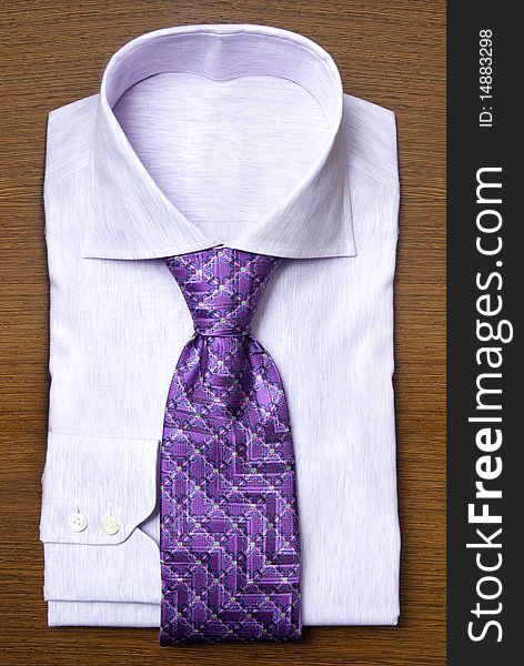 White shirt with violet tie on wooden shelf
