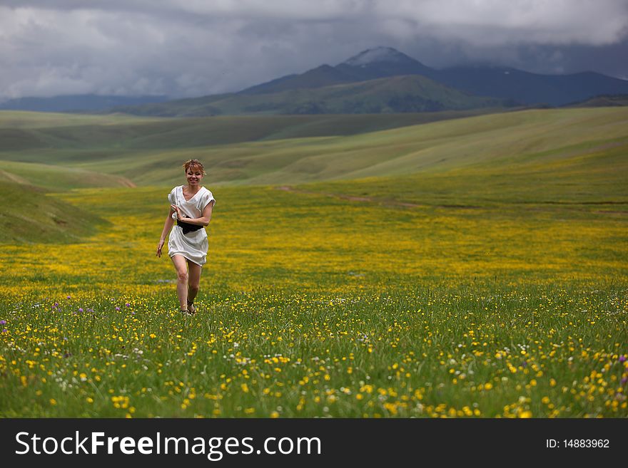 The girl on a beautiful field in mountains. The girl on a beautiful field in mountains