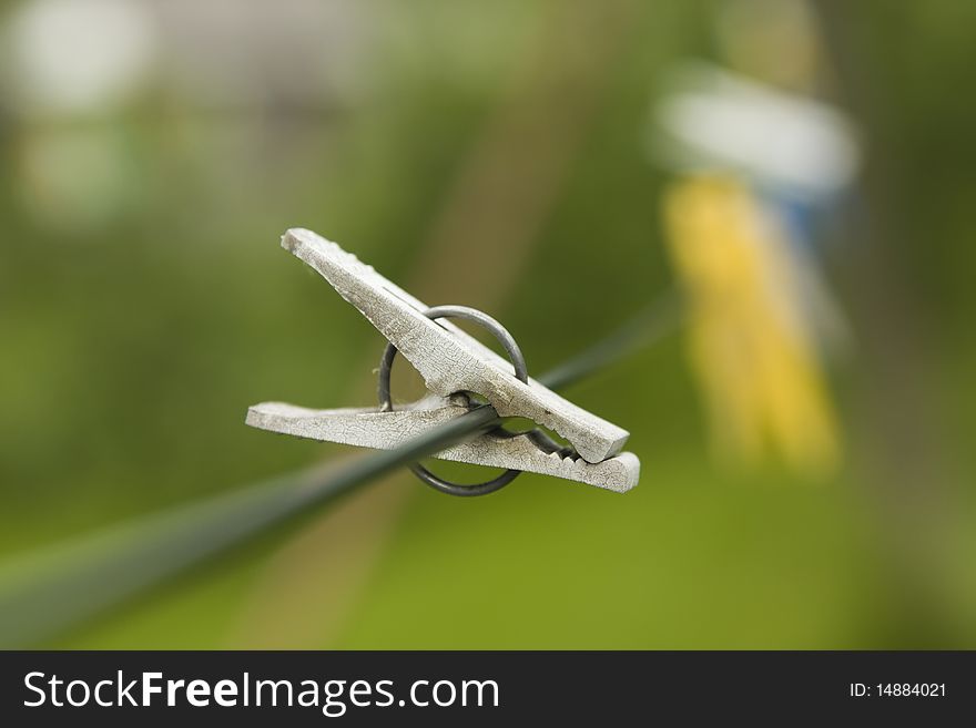 Close-up of old plastic clip hanging on rope with limited focus. Close-up of old plastic clip hanging on rope with limited focus