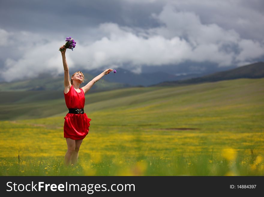 The girl on a beautiful field in mountains. The girl on a beautiful field in mountains