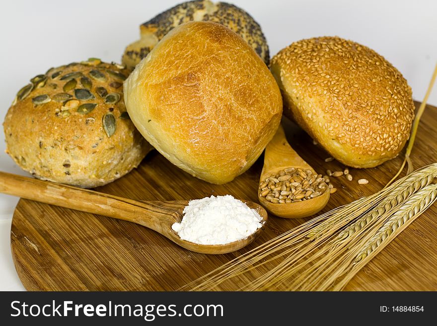 German roll bread with pumpkin and poppy seeds on the white background .